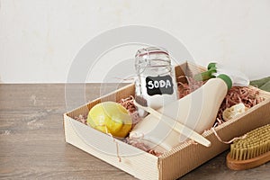soda in a jar, spray bottle, lemon and other cleaning products in a box