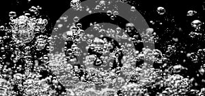 Soda water bubbles splashing underwater against black background