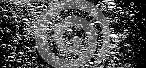 Soda water bubbles splashing underwater against black background