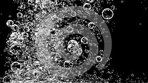 Soda water bubbles splashing underwater against black background