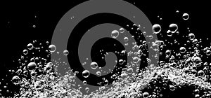 Soda water bubbles splashing underwater against black background