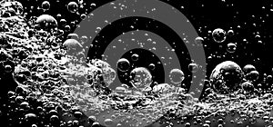 Soda water bubbles splashing underwater against black background