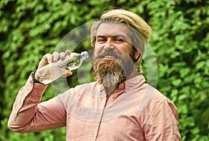 Soda water. Water balance. Man bearded tourist drinking water plastic bottle nature background. Summer heat. Thirsty guy