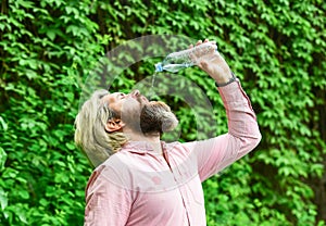 Soda water. Water balance. Man bearded tourist drinking water plastic bottle nature background. Thirsty guy drinking