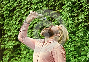 Soda water. Water balance. Man bearded tourist drinking water plastic bottle nature background. Thirsty guy drinking