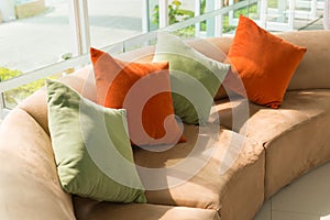 Sofa with colorful pillows in room with morning sunlight