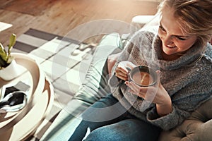 Sofa days are like mini vacations. a young woman relaxing on the sofa at home with a warm beverage.