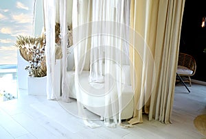 Sofa milky color and transparent curtains. Romantic setting