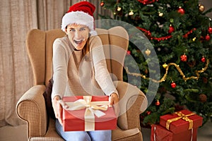 Sofa, surprise and portrait of woman with gift for Christmas, celebration and religious holiday at home in living room