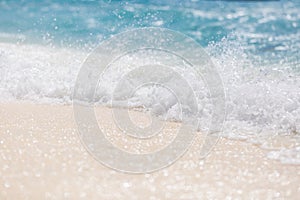 Soft blue ocean wave on clean sandy beach. Summer beach closeup template, waves splashing on white sand