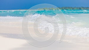 Soft blue ocean wave on clean sandy beach. Summer beach closeup template, waves splashing on white sand