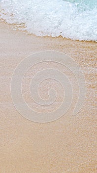 Soft Blue Ocean Wave On Sandy Beach. Background with copy space. Selective focus.