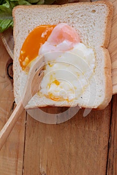 Soft-boiled egg with bread on wood background.
