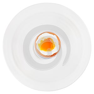 Soft boiled egg in egg cup on white plate