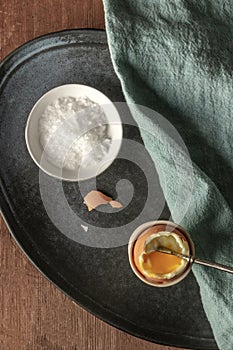 A soft-boiled egg in an eggcup with coarse sea salt and a spoon