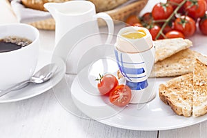 Soft-boiled egg in the morning with toast. In the background of