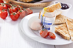 Soft-boiled egg in the morning with toast. In the background of