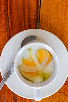 Soft boiled egg in white cup with spoon