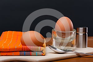 2 soft-boiled eggs on a wooden board.
