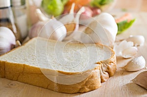 Soft bread with garlic on hopping board in kitchen courter