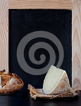 Soft cheese wedge in front of blank old blackboard carte. photo