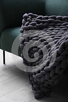 Soft chunky knit blanket on sofa indoors, closeup