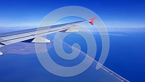 Soft clouds cover the sky during the flight. View of the wing of an airplane flying above the clouds at high altitude