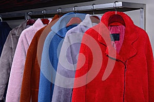 Soft coats hanging on rail in shop