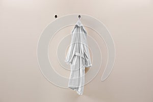 Soft comfortable bathrobe hanging on wall