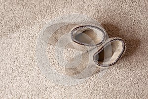 Soft cozy slippers at beige carpet floor