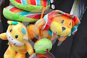 Soft cuddly toys hanging from a baby`s pushchair