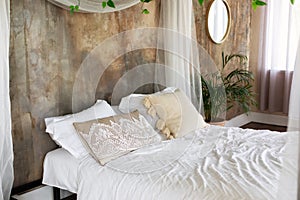 Soft different pillows, blanket and duvet cover on bed. Boho style Bedroom with bedding.