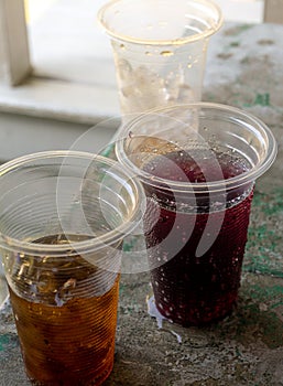 Soft drink and ice in the disposable plastic glasses