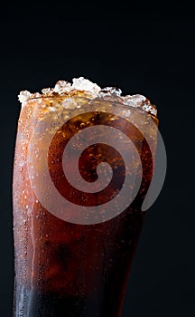 Soft drink with ice in glass isolated on dark background with co