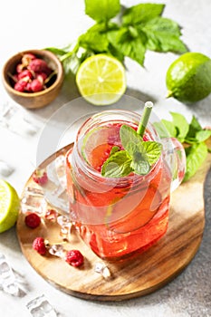 Soft drinks, healthy beverage. Refreshing summer glasses drink raspberry with mint lime and ice.