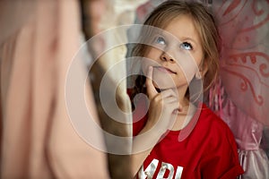 Soft Focus of a 5-6 Years Old Child Choosing her own Dresses from Kids Cloth Rack in Clothing Shop. Shopaholics Girl