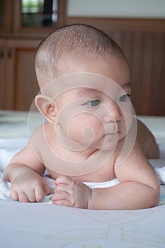 Soft Focus on Adorable curious infant  baby lay on stomach on the bed after taking a bath