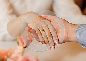 soft-focus close-up caucasian male holding woman hand diamond ring