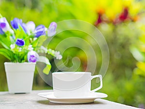 Soft focus of close up coffee cup in garden.