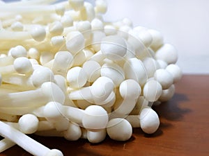 Soft Focus of enoki mushroom or golden Needle Mushroom on wooden table