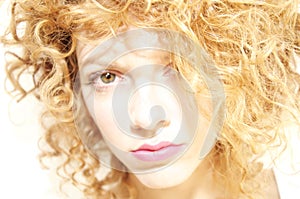 Soft focus face of a young woman with curly hair