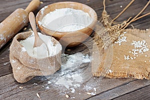 Soft focus, flour in bags, ears of wheat, barley, cooking, bread, and cookies arranged on a wooden tabletop in a rustic kitchen,