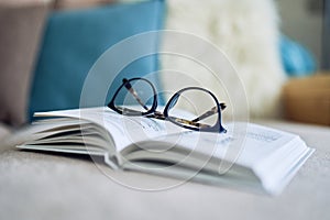 Soft focus glasses, book on the sofa. Abstract book blur background.