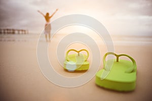 Soft focus on Green flip flop with happy woman open arms