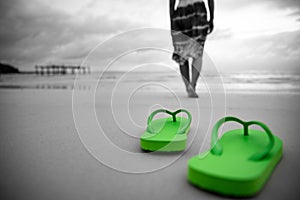 Soft focus on Green flip flop with sad woman walking