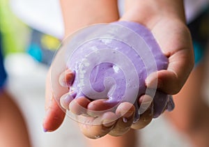 Soft focus of hand holding homemade toy called slime