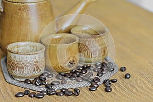 Soft focus image of coffee beans and coffee cups set on wooden b