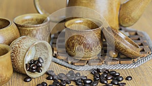 Soft focus image of coffee beans and coffee cups set on wooden b