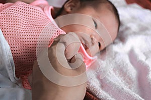 Soft focus of newborn tiny baby hand on parent