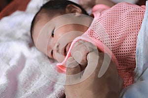 Soft focus of newborn tiny baby hand on parent